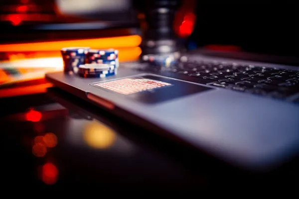 A woman smiling while playing online games on her laptop, surrounded by neon casino elements, showcasing WIN7JILI’s diverse game collection.