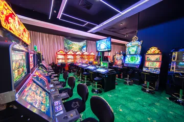 A man celebrating a winning moment on his laptop while gaming symbols float around him, capturing the excitement of WIN7JILI games.