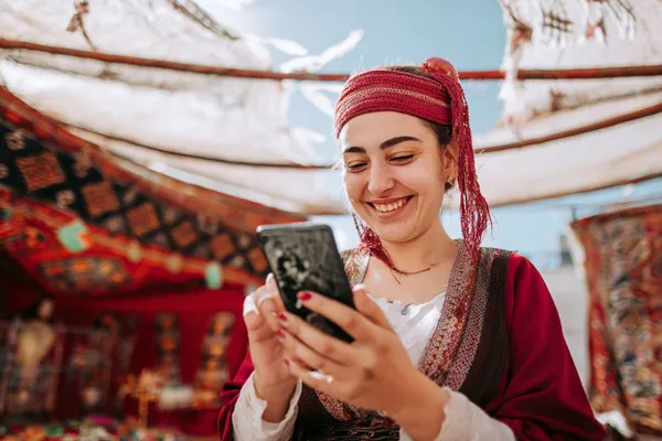 A player using their smartphone during a festive local event, representing WIN7JILI’s fully mobile-friendly casino.